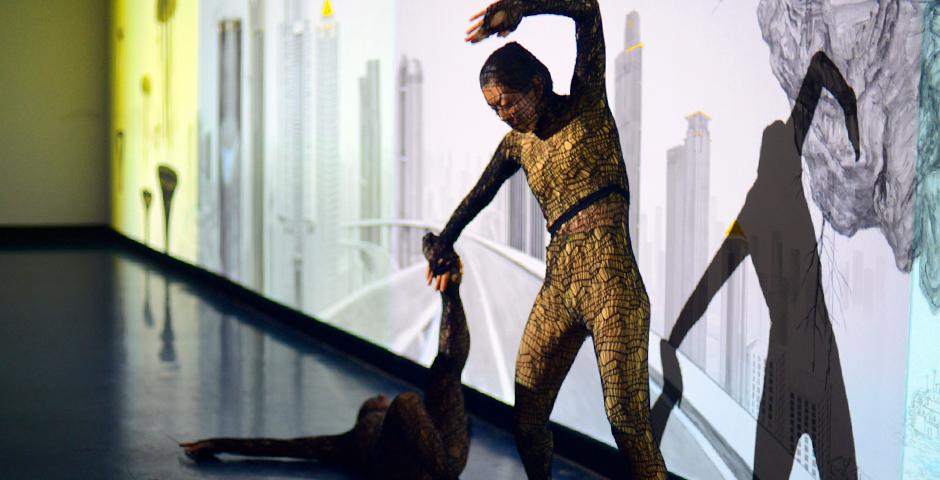 Emma Quong dances with the wall, physically representing sections of Qiu Anxiong’s painted mural. (Photo by: Michael Shi and Charlie Wang)