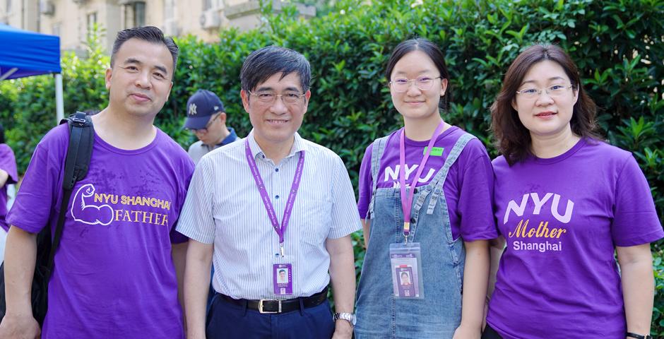 来自北京的武子初一家三口身着上纽大紫罗兰T恤，在宿舍楼前与童世骏校长合影。