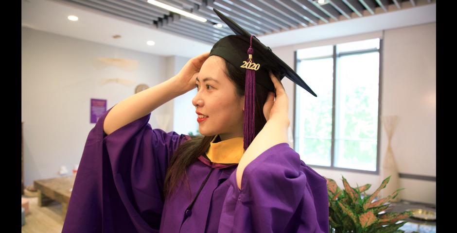 Data Analytics &amp; Business Computing graduate, Xinye Gong, MS ’20, adjusts her cap.