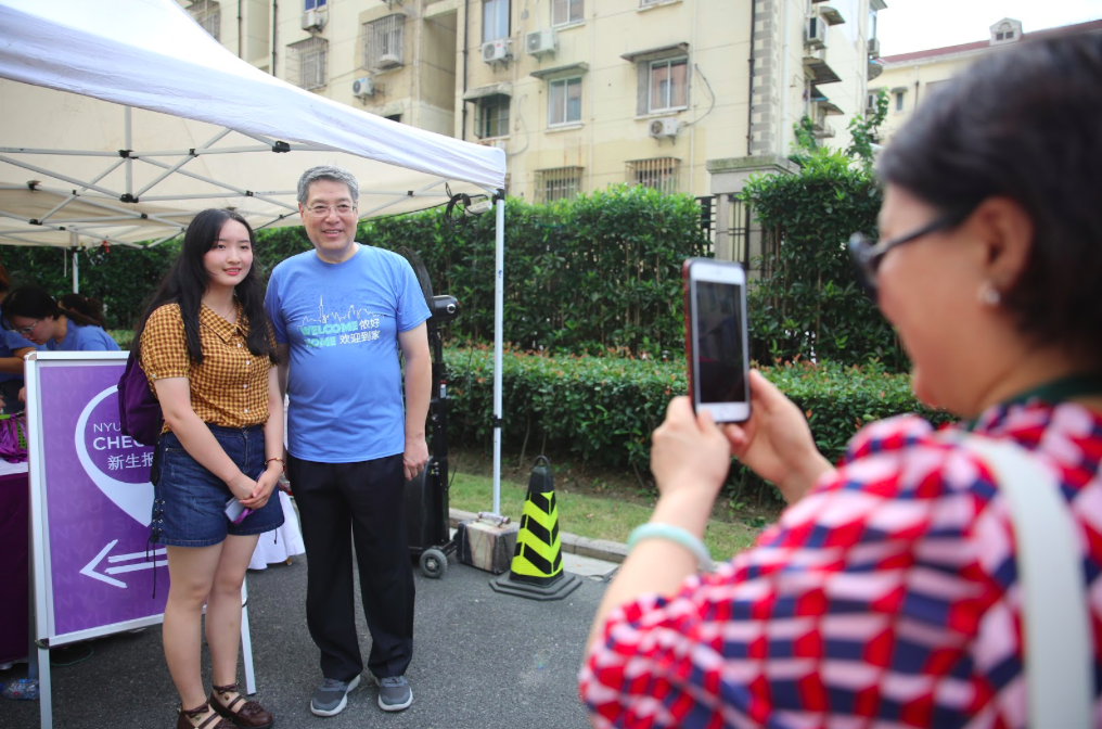 一大早，俞立中校长就到达金桥宿舍，迎接前来报到的中外新生与家长们。图为2023届学生贯晓艺在妈妈的陪同下前来报到，并与俞立中校长合影留念。
