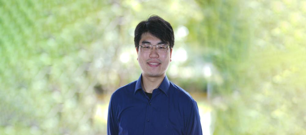 a headshot of eric with a green background 