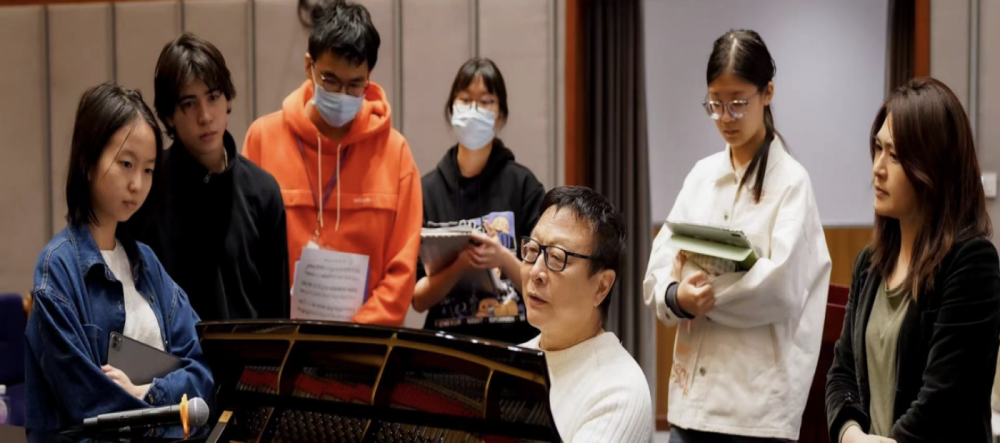 Students gather around Sheng at the Piano