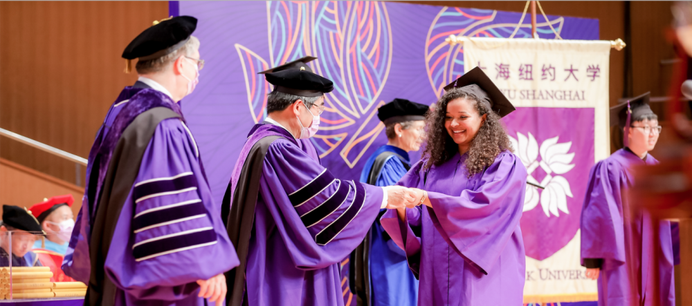 Graduate accepts diploma from Chancellor