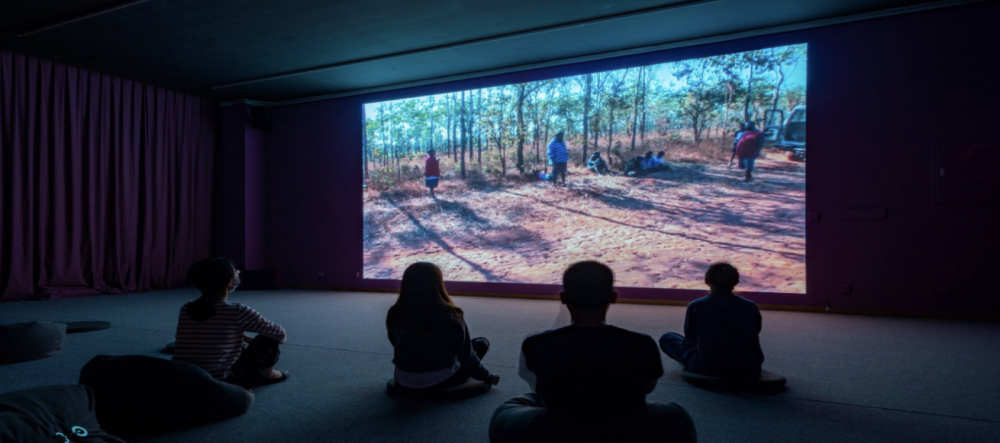 Students silhouetted against movie screen