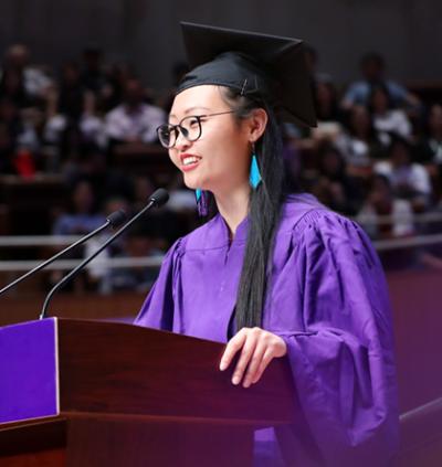 Chen speaks at podium at NYU Shanghai commencement