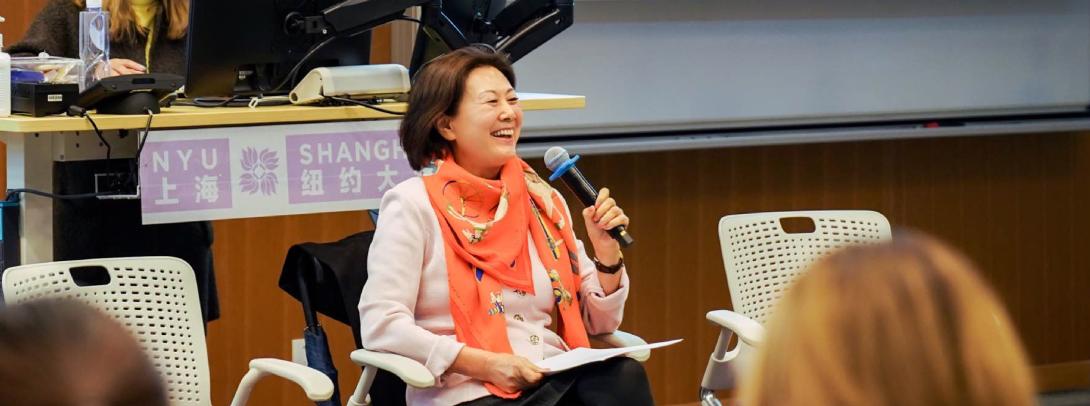 Hua Jiang smiling and holding a microphone