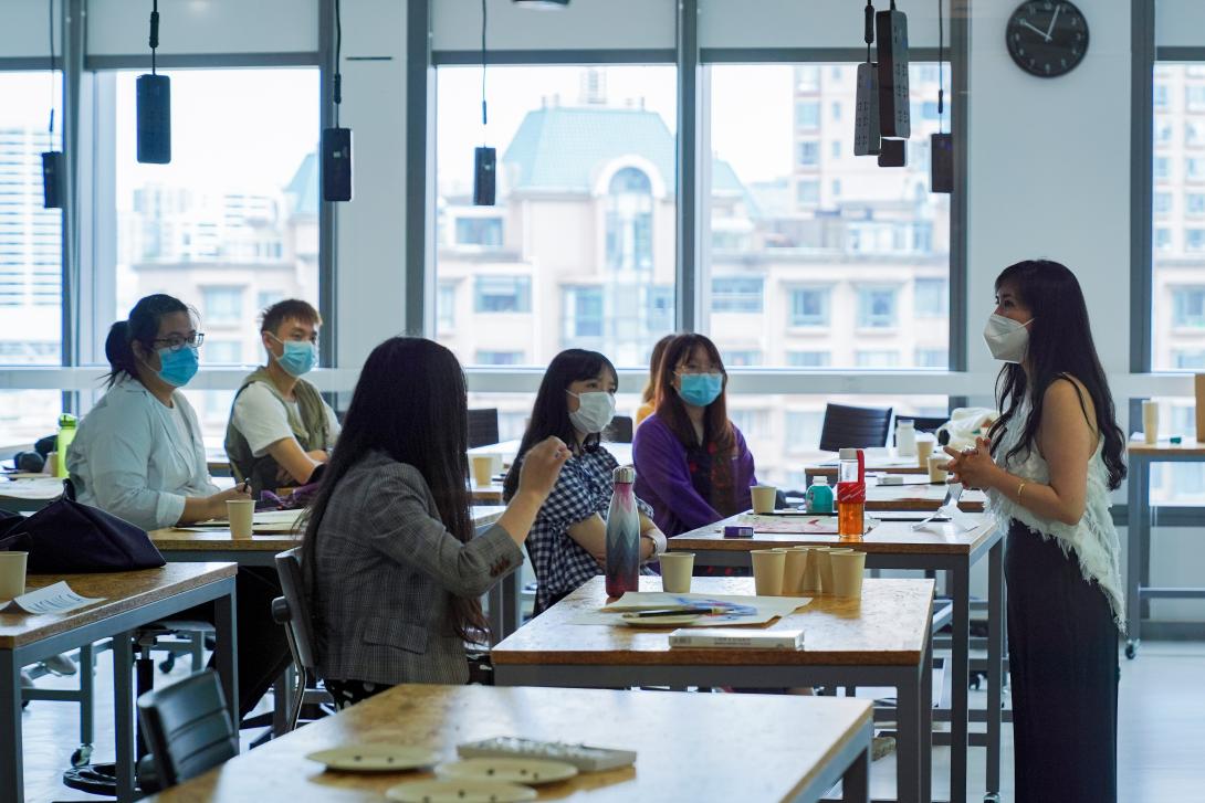 Professor and students engage in classroom discussion while wearing masks